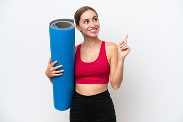 Young sport caucasian woman going to yoga classes while holding a mat isolated on white background pointing up a great idea