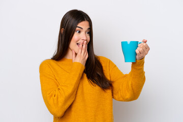 Young Brazilian woman holding cup of coffee isolated on white background with surprise and shocked...