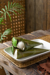 Traditional Malaysian kuih celorot sweet steamed coconut dessert wrapped in coconut leaf cones