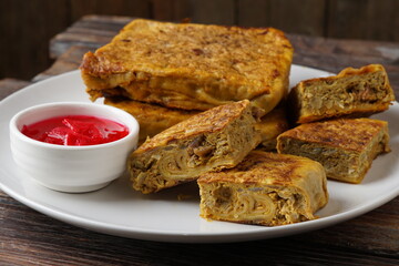 Close up of savory Malaysian murtabak filled with minced beef and chicken served as traditional street food on a plate