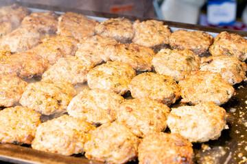 A sizzling, golden-brown pork cutlet freshly fried at a lively night market. The crispy coating and juicy meat inside make it a popular Taiwanese street food, tempting visitors with its aroma and irre