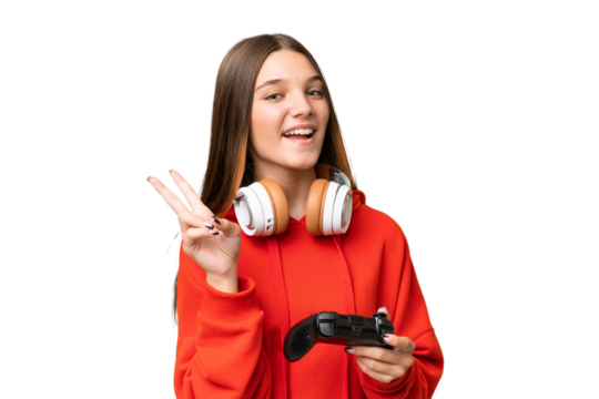 Teenager caucasian girl playing with a video game controller over isolated background smiling and showing victory sign