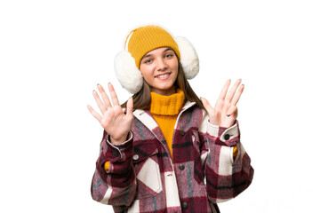 Teenager caucasian girl wearing winter muffs over isolated background counting nine with fingers