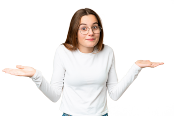 Teenager girl over isolated chroma key background having doubts while raising hands