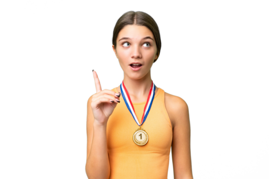 Teenager caucasian girl with medals over isolated background thinking an idea pointing the finger up