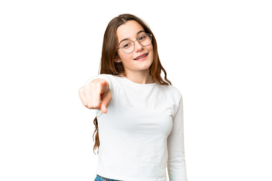 Teenager girl over isolated chroma key background pointing front with happy expression