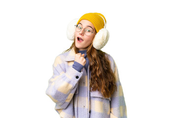 Teenager girl wearing winter muffs over isolated chroma key background celebrating a victory