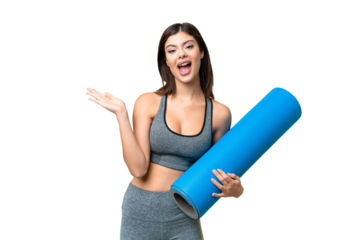 Young sport woman going to yoga classes while holding a mat over isolated chroma key background with shocked facial expression