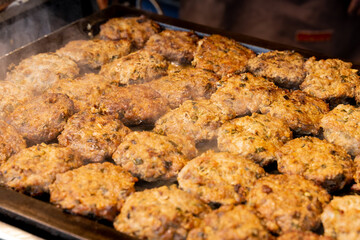 A sizzling, golden-brown pork cutlet freshly fried at a lively night market. The crispy coating and juicy meat inside make it a popular Taiwanese street food, tempting visitors with its aroma and irre