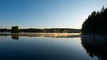 Calm Lake at Sunrise with Light Fog and Woodland