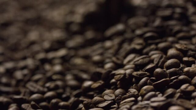Coffee beans roasting and tumbling inside industrial roaster, revealing rich brown texture and intricate movement during artisan coffee production process