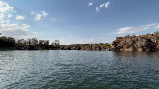 Tranquil boating scene at Bhedaghat during sunset, featuring serene waters, marble cliffs, and the golden glow of dusk.