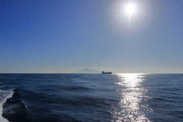 container ships on Strait of Gibraltar with morocco mountains in background