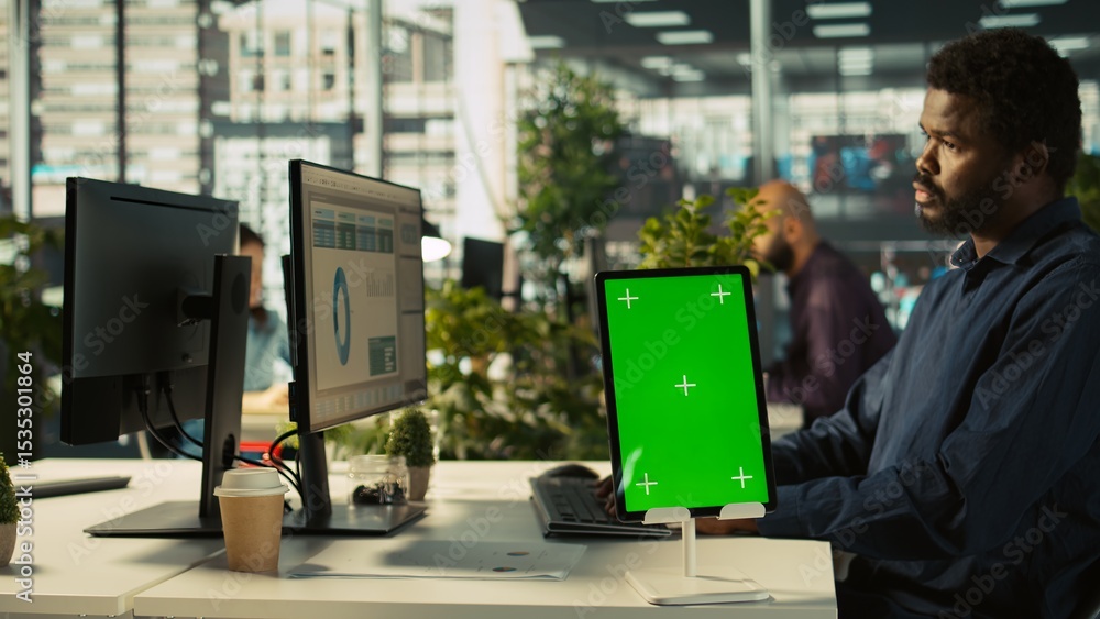 Poster close up of green screen tablet in front of employee checking progress done on project. chroma key d