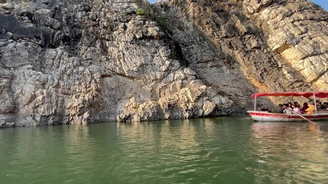 Tranquil boating scene at Bhedaghat during sunset, featuring serene waters, marble cliffs, and the golden glow of dusk.