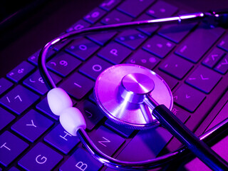 Medical stethoscope lies on a computer keyboard, online medicine
