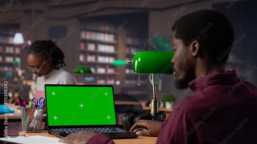 Poster college student looks at a copy space on laptop while collecting notes from reliable academic source