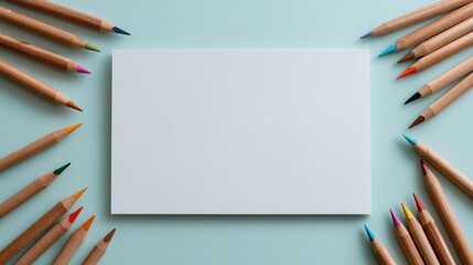 Fototapeta premium Clean white paper with colored pencils on pastel mint background