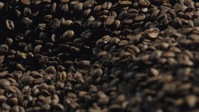 Roasted coffee beans cascading and pouring in slow motion, revealing rich brown texture and captivating aromatic essence of premium coffee seeds