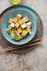 Bowl of smoked tofu cheese with marinated egg on a beige granite background, vertical shot with space, top view