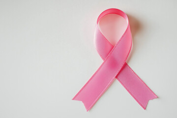 pink cancer ribbon symbol placed on a white surface