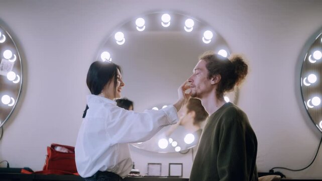 A makeup artist gently preps the client's skin, cleansing and priming before starting the makeup.