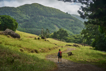 Beautiful European woman hiking in La Vallée de Ferney, Mauritius. Outdoor adventure in lush tropical forest with scenic mountain views. Active lifestyle and nature exploration.