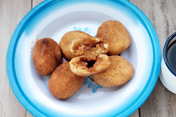 A plate of Misro, a traditional Indonesian fried cassava cake filled with sweet palm sugar, perfect for an afternoon snack or breakfast. Serve on vintage enamel plate
