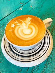 Artistic Cappuccino on Striped Saucer