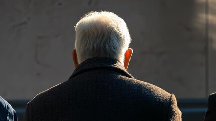 b. Elderly men sitting in sunlight from behind