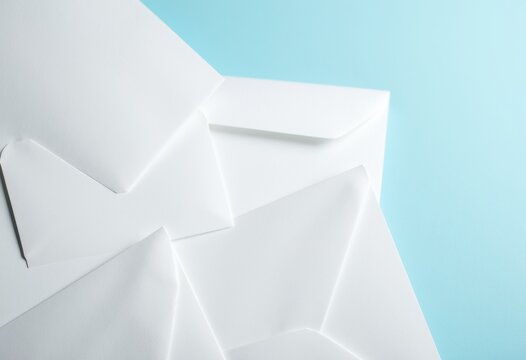 A collection of white envelopes arranged on a light blue background