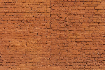 A textured red brick wall bears the marks of time and urban history. Its warm hue and rough surface evoke a sense of nostalgia, craftsmanship, and industrial charm.