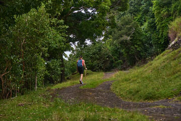 Beautiful European woman hiking in La Vallée de Ferney, Mauritius. Outdoor adventure in lush tropical forest with scenic mountain views. Active lifestyle and nature exploration.