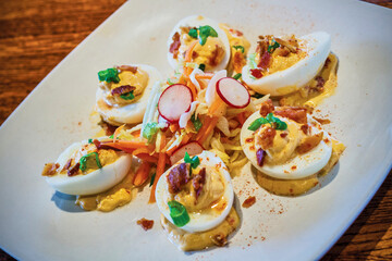 fancy deviled eggs topped with bacon, radish, and green onions