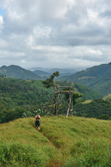 Beautiful European woman hiking in La Vallée de Ferney, Mauritius. Outdoor adventure in lush tropical forest with scenic mountain views. Active lifestyle and nature exploration.