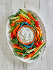 ranch dip with fresh carrots, celery sticks, cherry tomatoes, and broccolini