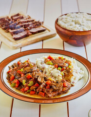 slices of braised pot roast topped with a mushroom gravy with carrots and celery