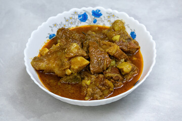 Delicious homemade beef curry in white bowl. Oily, healthy, protein rich meal.