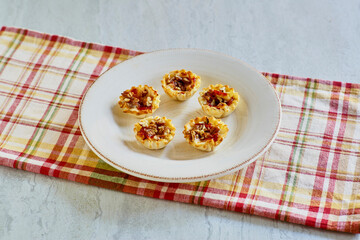 phyllo dough cups stuffed with brie cheese and topped with a sweet and spicy red sauce