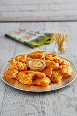 southern fried chicken and alligator bites served with a spicy dipping sauce on a platter