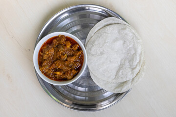 Delicious Bengali Beef Bhuna Curry with Roti on Steel Plate, Wooden Surface. Spicy, Juicy, Ready to Eat Meal. Top View Food Photography.