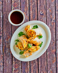 spring rolls with cabbage, carrot, and green onion and a soy dipping sauce