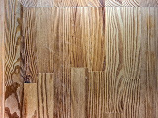 Wooden floor with natural grain pattern and variations in color, creating a rustic appearance. The planks are arranged in a parallel alignment, showing distinct texture and subtle imperfections