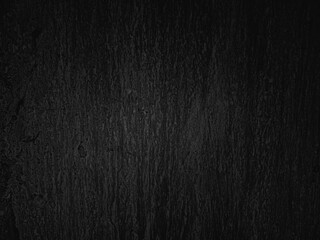 Dark textured surface with subtle vertical patterns and variations in shades of black and gray, creating an abstract, mysterious appearance with a natural, rough finish