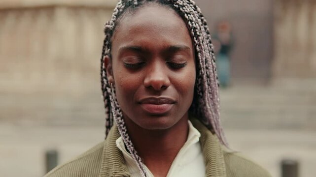 Cute and happy beautiful black woman with dreadlocks having a good time, smiling, traveling and enjoying a walk in the city