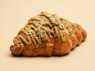 Freshly baked pastry with topping, on beige background