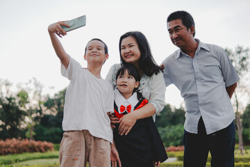 Asian young child wear a graduation gown and family take group photos to capture memories of...