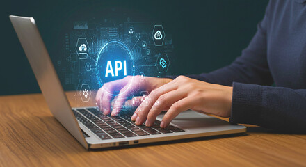 Person typing on laptop with api graphic overlay showing cloud and network connectivity icons around api