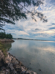 a waterscape view with an urban or industrial area backdrop under a mostly cloudy sky.
