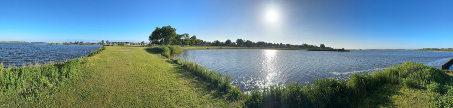 Panoramic picture of a small beach at a lake